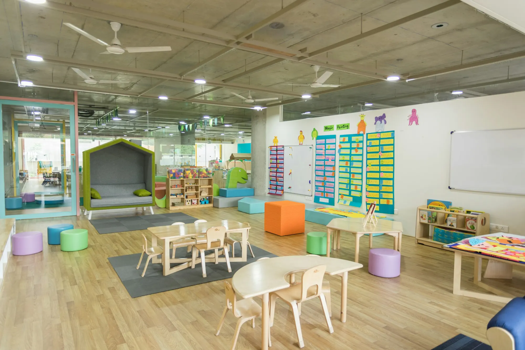 Bright, sunlit classroom with small tables and chairs