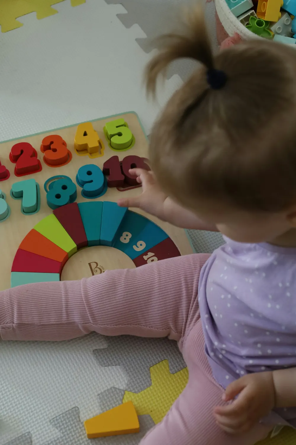 Toddler playing with a wooden counting toy